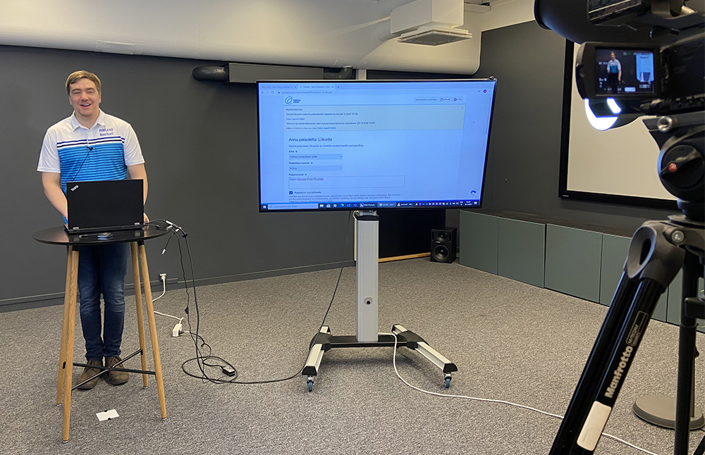 Markus Tihumäki pitämässä esitystä videokameran edessä